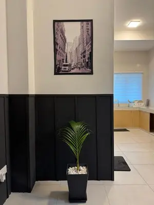 a plant in a pot next to a black wall at Ipoh Modern Family Retreat in Ipoh