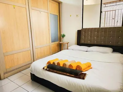 a bedroom with a bed with yellow towels on it at Klang Prima Bayu Apartment, Taman Bayu Perdana, 42000 Klang in Gua Sai