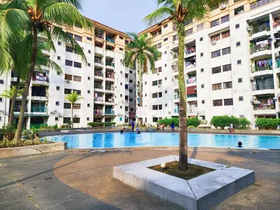 a palm tree in front of a large building at Klang Prima Bayu Apartment, Taman Bayu Perdana, 42000 Klang in Gua Sai