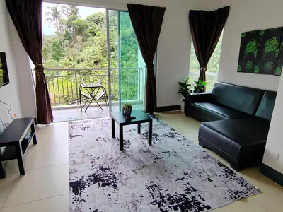 a living room with a couch and a table at Golden hill somersqaure 3 bed room islam apartment in Tanah Rata