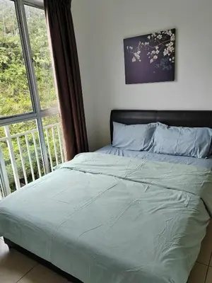 a bed in a bedroom next to a window at Golden hill somersqaure 3 bed room islam apartment in Tanah Rata