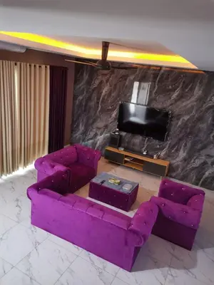 a living room with a purple couch and a tv at Sbb Star Resources Homestay in Sungai Petani