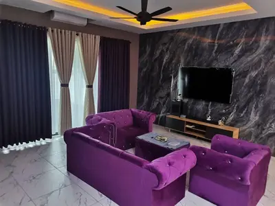 a living room with purple couches and a tv at Sbb Star Resources Homestay in Sungai Petani