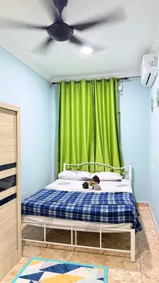a bedroom with a bed with a green curtain at Mk homestay butterworth in Butterworth