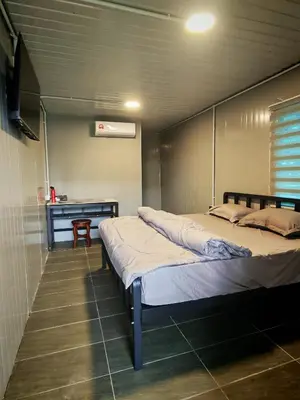 a bedroom with two beds and a desk at deLotus Villa in Simpang