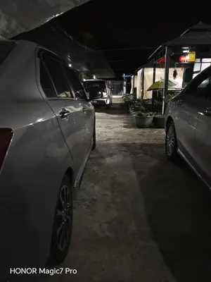 two cars parked in a parking lot at night at deLotus Villa in Simpang