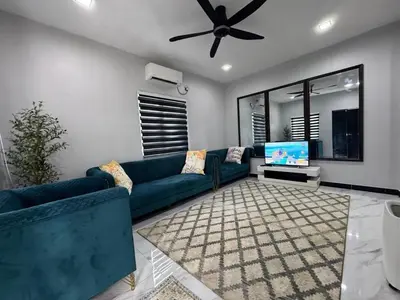 a living room with a blue couch and a tv at Omah Kebun Private Pool in Sungai Besar