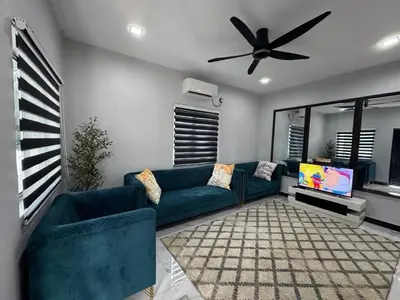 a living room with a blue couch and a ceiling fan at Omah Kebun Private Pool in Sungai Besar