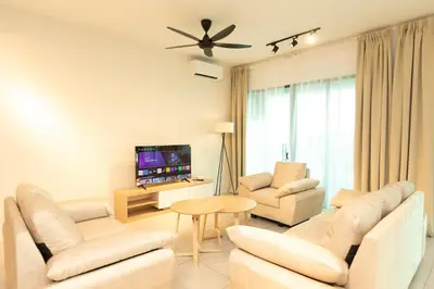 a living room with white furniture and a flat screen tv at Meritus Residensi Seaview Pent Hauz 3BR 10Pax in Perai