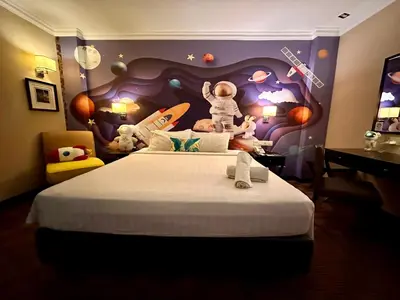 a bedroom with a large bed with stuffed animals on it at Merchant Hotel in George Town