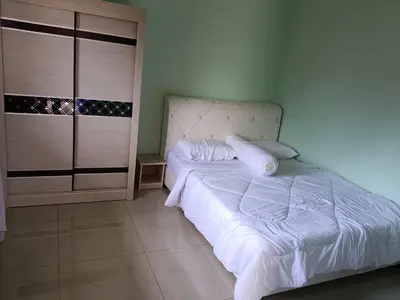 a bedroom with a bed with white sheets and pillows at Rsstay Villa in Lunas
