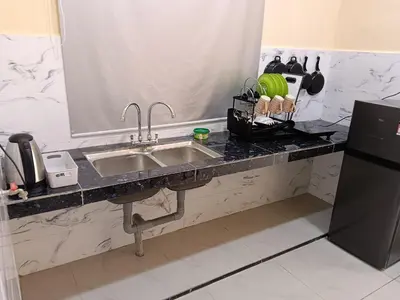 a kitchen counter with a sink and a refrigerator at Rsstay Villa in Lunas