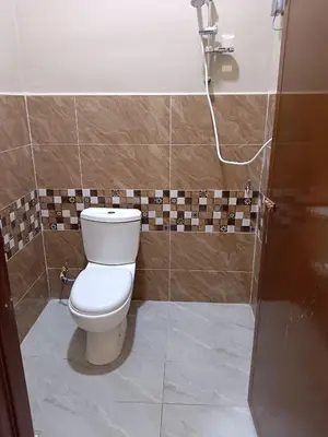 a bathroom with a toilet and a shower at Rsstay Villa in Lunas