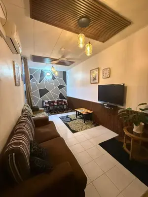 a living room with a couch and a flat screen tv at JJ Homestay Taman Manggis in Balik Pulau