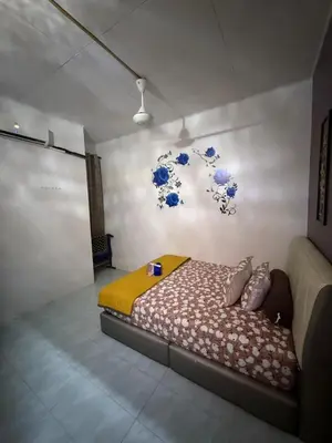 a bedroom with a bed with blue flowers on the wall at JJ Homestay Taman Manggis in Balik Pulau