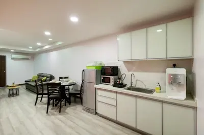 a kitchen with white cabinets and a table with chairs at Gaia Realty Homestay, Private & Convenient Stay in Georgetown in George Town
