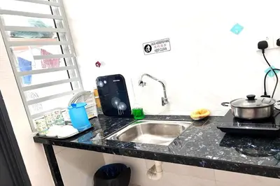 a kitchen counter with a sink and a microwave at Homestay MyKulim in Kulim
