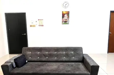 a leather couch in a room with a door at Homestay MyKulim in Kulim