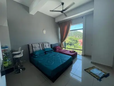 a bedroom with a bed and a large window at RZHOMESTAy in Gua Musang