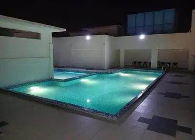 a large swimming pool with green water at night at RZHOMESTAy in Gua Musang