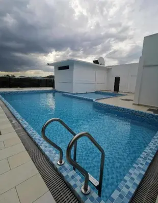 a large swimming pool with two metal hand rails in it at RZHOMESTAy in Gua Musang