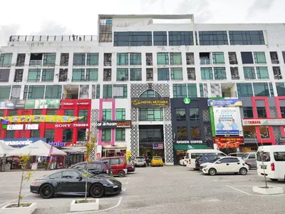 a parking lot with cars parked in front of a building at RZHOMESTAy in Gua Musang