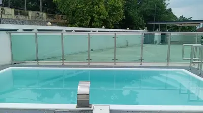 a blue swimming pool with a tennis court at BungalowD Pool Villa 7R6B with Netflix Enjoyable Movies & Dramas in Ipoh