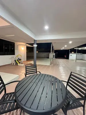 a wooden table and chairs in a room with a room at BungalowD Pool Villa 7R6B with Netflix Great Movies & Dramas in Ipoh