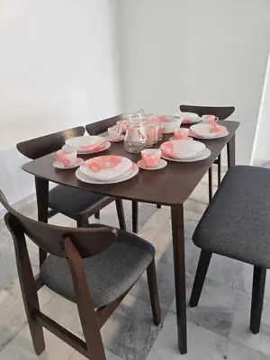 a wooden table with plates and dishes on it at PJ Homestay in Bayan Lepas