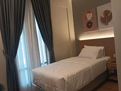 a small bedroom with a bed and a window at Karasky Hotel in Simpang Ampat
