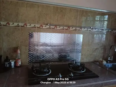 a kitchen counter with two pots and pans on a stove at Zarif homestay in Gua Sai