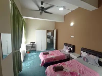 a bedroom with two beds and a ceiling fan at DarulMakmur Apartment in Brinchang