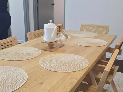 a wooden table with white plates and a jug on it at Kea Farm Stay in Brinchang
