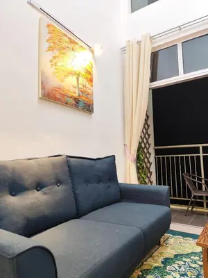 a blue couch in a living room with a painting on the wall at Bukit Urbane Night Market CH in Brinchang