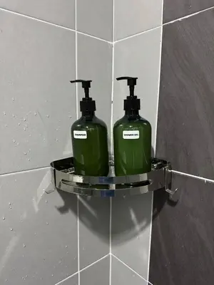 two green soap bottles on a shelf on a wall at Modern & Cozy Home Stay in Kampar