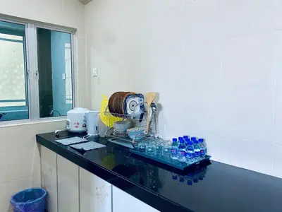 a kitchen with a counter with bottles of water on it at SK Holiday Apartment in Tanah Rata