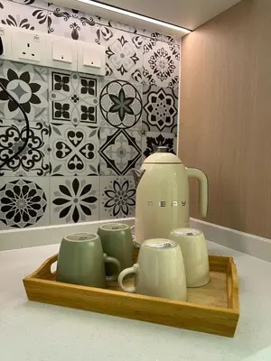 a tea pot and cups on a wooden tray at Karaoke Cozy Landed Home at Sutera n Paradign for 10pax in Gua Sai