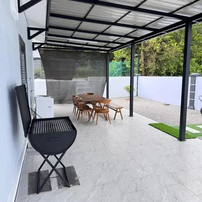 a patio with a wooden table and chairs and a table and a table at Homestay D'Ammar Private Pool in Gua Sai
