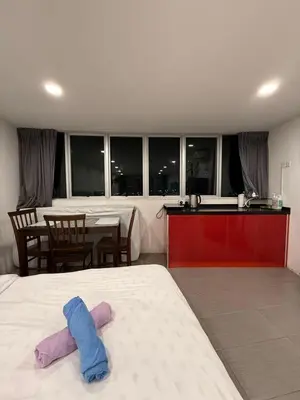 a bedroom with a bed and a kitchen with a table at THE CEO 3 BEDROOM near USM SPICE ARENA PANTAI SPECIALIST AIRPORT in Bayan Lepas