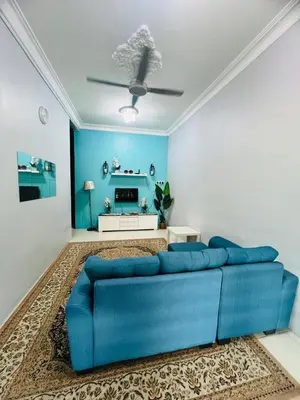a blue couch in a living room with a blue wall at Pa&Ma HomeStay Kulim III 3R2B FullyAircond in Gua Sai