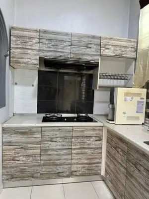 a kitchen with wooden cabinets and a stove at Pa&Ma HomeStay Kulim III 3R2B FullyAircond in Gua Sai
