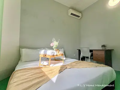 a bedroom with a bed and a table with flowers on it at Bercham Landed CornerLot 6BR with Karaoke Set & BBQ in Ipoh