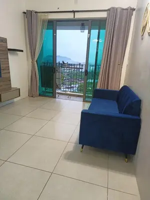 a living room with a blue couch and a balcony at Meritus in Perai