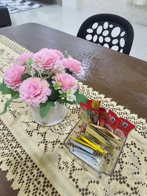 a vase filled with pink flowers on a table at DhiyaAdraHomestay in Chemor