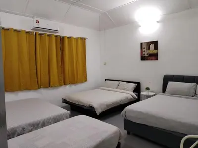 two beds in a room with yellow curtains at Gurney PENstay in George Town