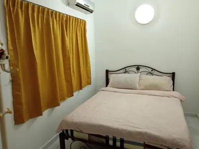 a bedroom with a bed and a yellow curtain at Gurney PENstay in George Town