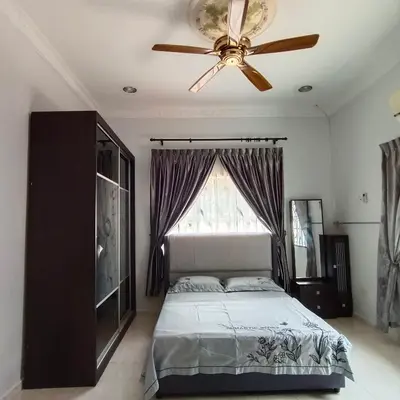 a bedroom with a bed and a ceiling fan at Puterihomestay in Gua Sai