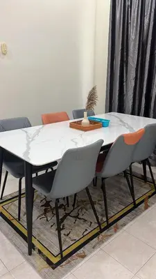 a dining room table with chairs and a white table at Puterihomestay in Gua Sai