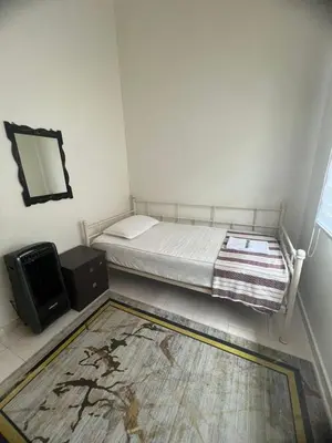 a bedroom with a bed and a mirror and a rug at Puterihomestay in Gua Sai