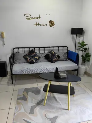 a living room with a bed and a table at Warmth Nest4U Homestay Butterworth in Butterworth